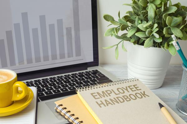 employee handbook with laptop